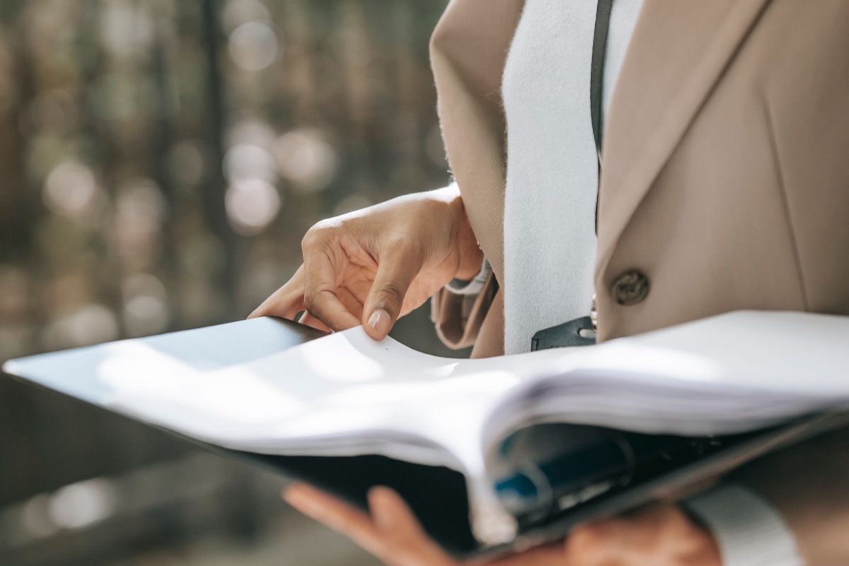 Hands turning the pages of an open ring binder